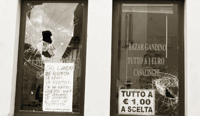 Le vetrate del phone center a Gandino infrante dai vandali. Alcuni residenti hanno lasciato un messaggio di solidarietà