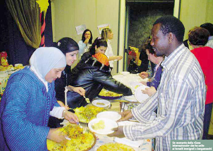 Un momento della «Cena internazionale» che ha unito ai fornelli immigrati e bergamaschi