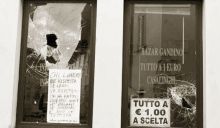 Le vetrate del phone center a Gandino infrante dai vandali. Alcuni residenti hanno lasciato un messaggio di solidarietà